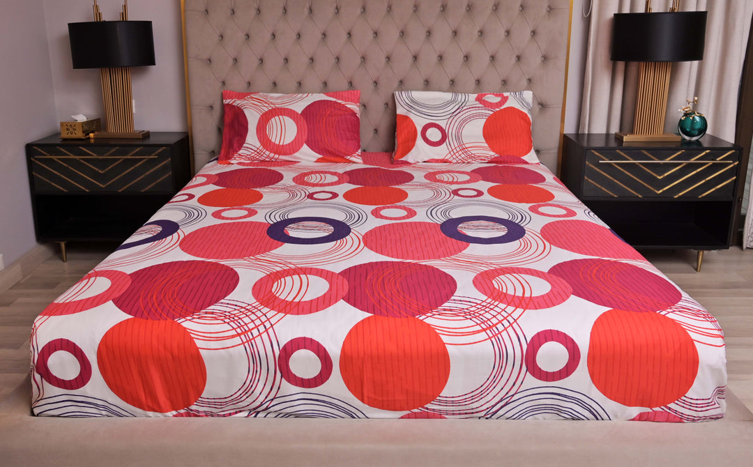 Bed with a colorful circular patterned bedspread in a bedroom setting.