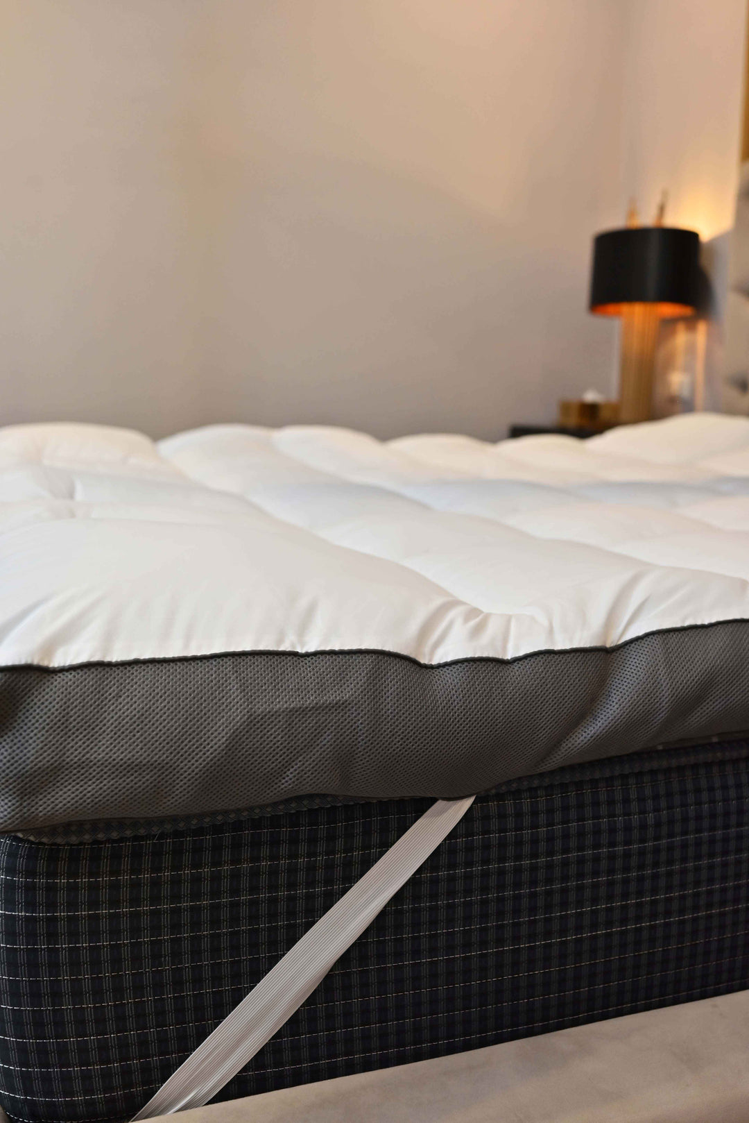 Mattress with a white cover on a bed in a bedroom setting.