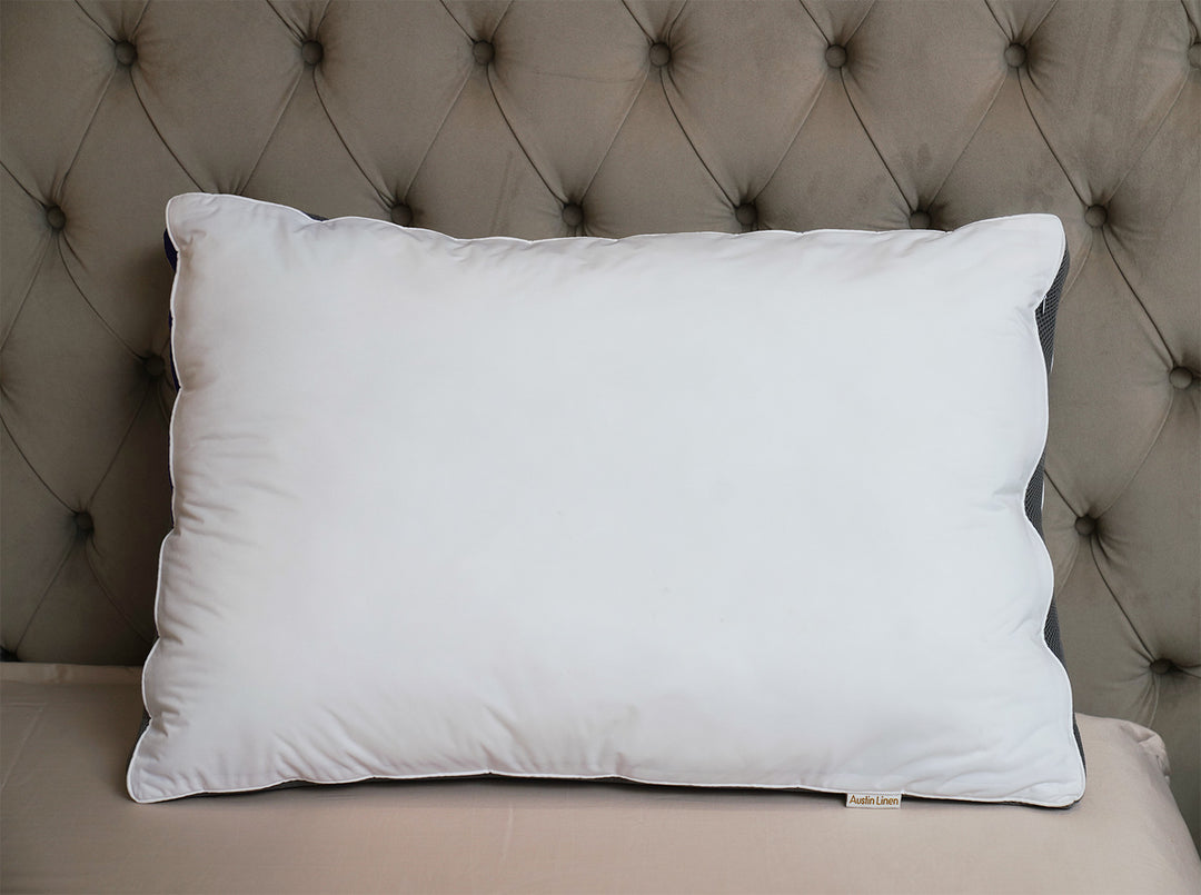 White pillow on a beige cushion with a tufted headboard in the background