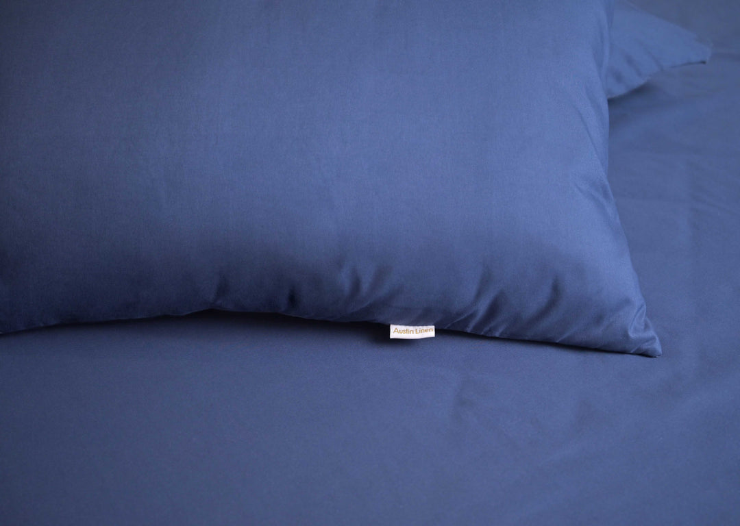 Blue pillow on a matching blue bedspread