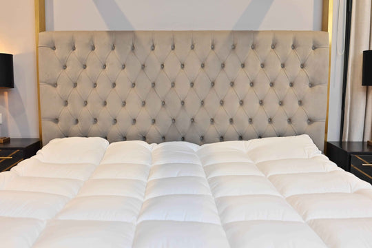 Bed with tufted headboard and white bedding in a bedroom setting