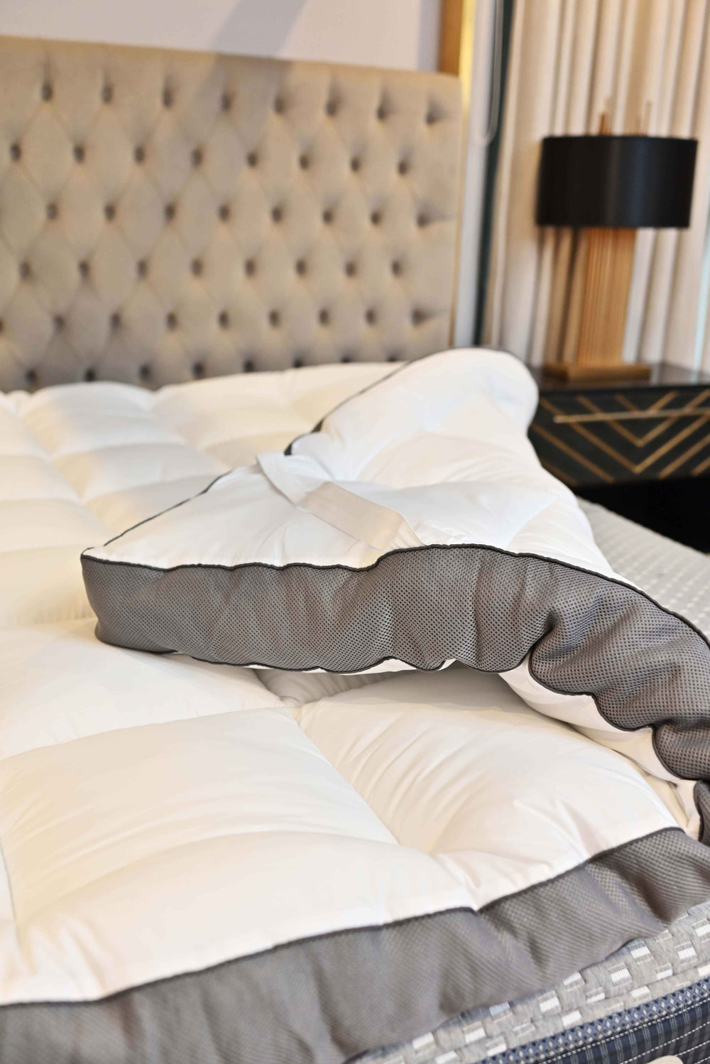 Gray and black pillow on a bed in a bedroom setting