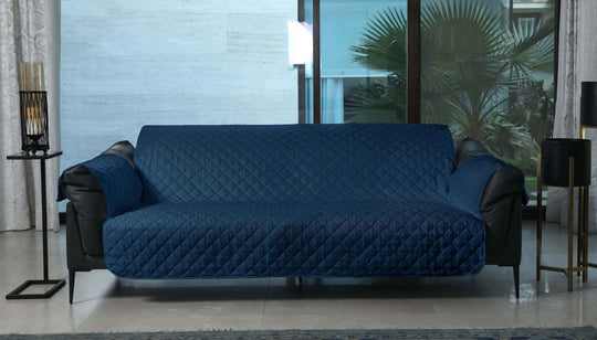 Blue quilted sofa cover on a black sofa in a modern living room.