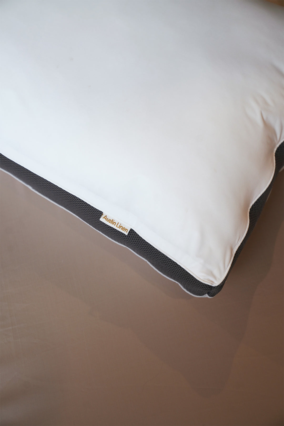 White pillow with a brand label on a brown surface